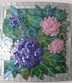 there is a painting made out of glass with flowers on it and leaves around the edges