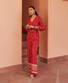 Make a statement in this stunning red printed jumpsuit, elevated with a hand-embroidered waistband for added glam. This chic ensemble effortlessly combines bold style with intricate detailing, making it perfect for both casual outings and special occasions. Traditional Red Floral Embroidered Kaftan, Luxury Red Printed Kaftan, Red Embroidered Long Sleeve Kaftan, Red V-neck Kaftan With Vibrant Print, Red Printed V-neck Jumpsuit, Printed Jumpsuit, Bold Fashion, Hand Embroidered, Special Occasion