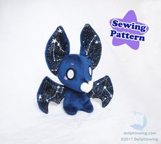 a blue stuffed animal with stars on it's wings, sitting in front of a white background