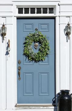 a blue front door with a wreath on it