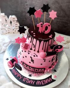 a pink and black birthday cake with stars on it