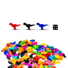 several different colored toy dinosaurs and dices on a white background