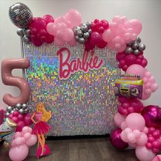 balloons and streamers decorate the entrance to a barbie themed birthday party