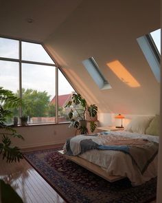 a bed sitting under two windows in a bedroom next to a rug on the floor