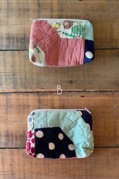 two zippered pouches sitting on top of a wooden floor next to each other