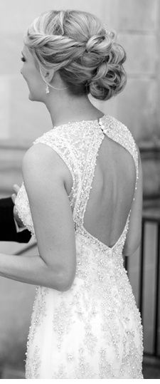 a black and white photo of a woman with her back to the camera, wearing a wedding dress