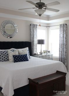 a bedroom with a bed, dresser and ceiling fan in the middle of the room