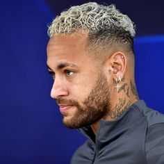 a close up of a person with tattoos on his face and hair in a bun