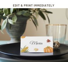 a place card sitting on top of a black plate next to a potted plant