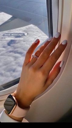 a woman's hand on an airplane window sill