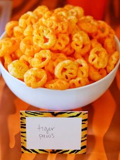 there is a bowl full of cheetos next to a sign that says tiger paws