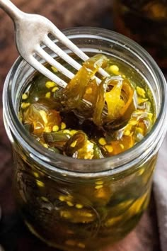 a fork is stuck into a jar filled with pickled vegetables