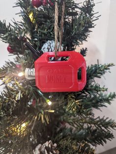 an ornament hanging from a christmas tree with the words money in red on it