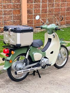 a moped parked on the side of the road with a cooler strapped to it's back