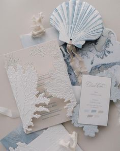 the wedding stationery is laid out on top of each other, including a fan