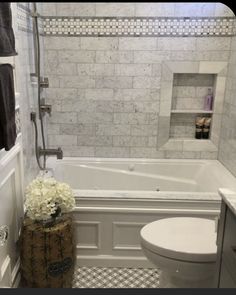 a white toilet sitting next to a bath tub in a bathroom with black and white checkered flooring