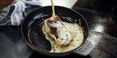 a frying pan filled with food on top of a stove