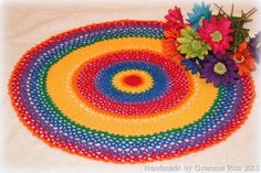 a crocheted placemat with flowers on it and the center piece is multicolored