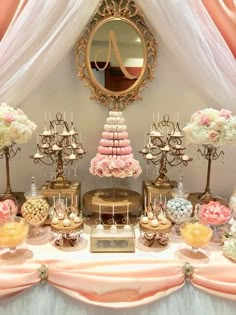 a table topped with lots of desserts next to a mirror