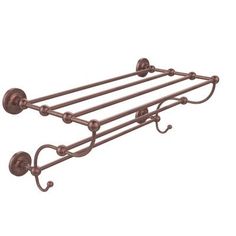 an old fashioned metal shelf with four hooks and two bars on the bottom, one is holding