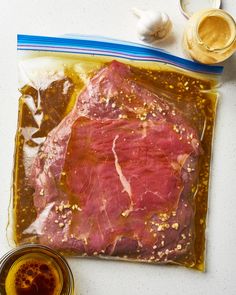 a piece of meat sitting on top of a bag next to some condiments