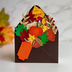 a thanksgiving card with an envelope full of autumn leaves and pumpkins on the inside