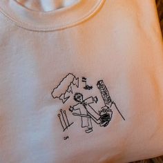 an embroidered t - shirt with a drawing of a skier and skis on it