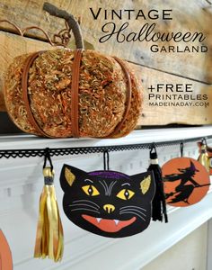 vintage halloween decorations are hanging on the mantle in front of a fireplace with an orange pumpkin and black cat