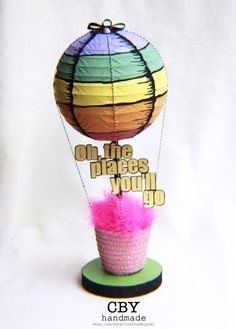 a hot air balloon that is on top of a stand with the words on the place you'll go