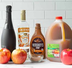 apples, milk, and other ingredients for apple cider punch on a white counter