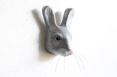 a gray rabbit head mounted to the side of a wall