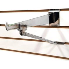 a pair of scissors are attached to the side of a metal wall mounted shelf with wood slats