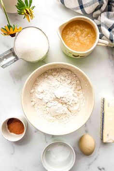 ingredients to make an easy pie laid out on a marble counter top, including flour, eggs and butter