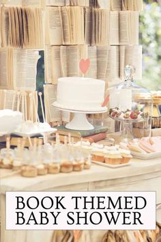 a table topped with lots of desserts and cakes next to a wall of books