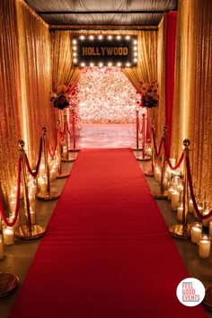 a red carpeted aisle is lined with candles and decorated with gold draping