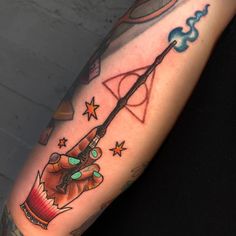 a harry potter hogwarts wand tattoo on the right arm and shoulder with stars around it