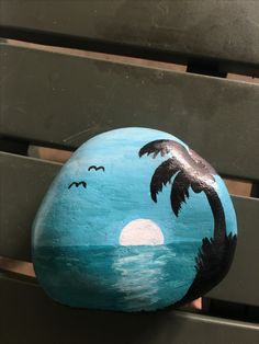 a painted rock sitting on top of a bench