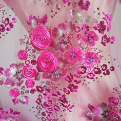 pink flowers and sequins on a white fabric with silver dots in the center