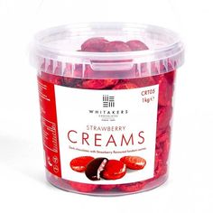 a plastic container filled with strawberries covered in creams on top of a white surface