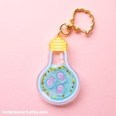 a light bulb shaped keychain on a pink background