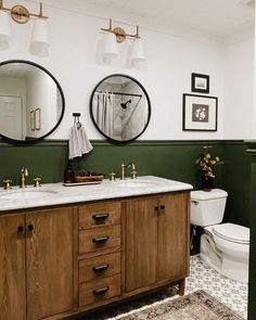 a bathroom with two mirrors above the sinks and a toilet in front of each other