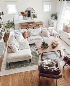 a living room filled with lots of furniture and decor on top of hard wood floors