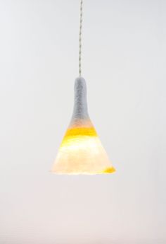 a yellow and white light hanging from a ceiling