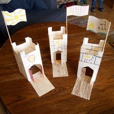 three paper castles sitting on top of a table next to each other with flags sticking out of them