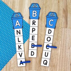 three blue and white letters are placed next to each other on top of a wooden table