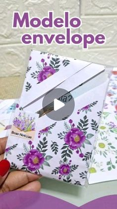 a hand holding an envelope with flowers on it and the words modelo envelope