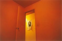 an open door with a painting hanging on the wall behind it in a red room