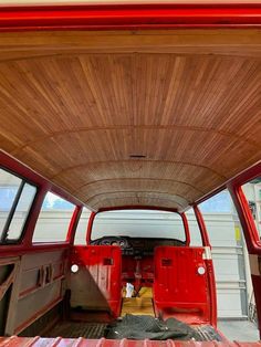 the interior of a red van with wood paneling