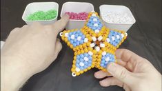 a hand is holding a star shaped beaded object