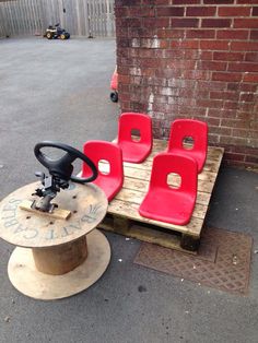 some red chairs sitting on top of a wooden table next to a skateboard and wheel